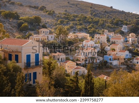 Symi Island, Greece. Greece islands holidays from Rhodos in Aegean Sea. Colorful neoclassical beautiful houses on hillsides of a Greek island during sunset. Holiday travel background.