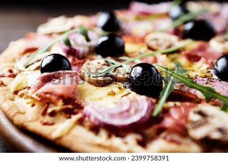 Pizza with ham, champignon mushrooms, mozzarella cheese, black olives and fresh rucola. Close up.  Royalty-Free Stock Photo #2399758391