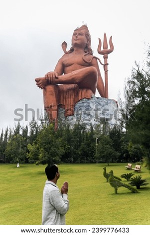 devotee praying to the hindu god lord shiva huge isolated statue at morning image is taken at The Statue of Belief or Vishwas Swaroopam nathdwara rajasthan india.