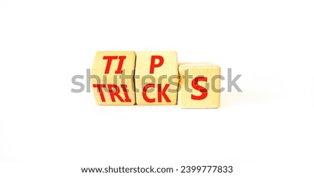 Tips and tricks symbol. Turned wooden cubes and changed the word tricks to tips. Beautiful white table, white background. Business, tips and tricks concept. Copy space.