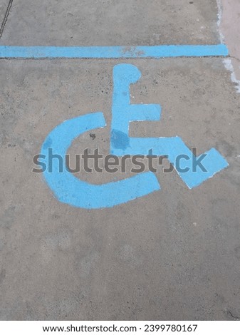 A blue parking space for people with disabilities, with a wheelchair sign