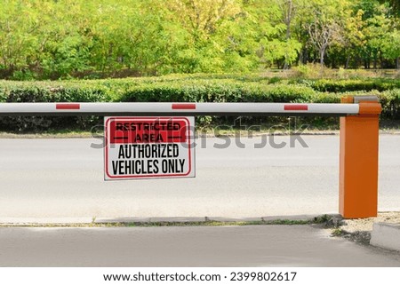 Sign with text Restricted Area Authorized Vehicles Only on boom barrier outdoors