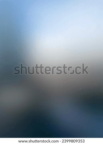 Abstract blur photo on frosted glass widow of a textured colorful blur random wallpaper full frame grades of blue grey gray black brown white with ligths effect design graphic 