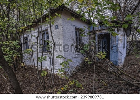 Cottage in Illinci abandoned village in Chernobyl Exclusion Zone, Ukraine Royalty-Free Stock Photo #2399809731