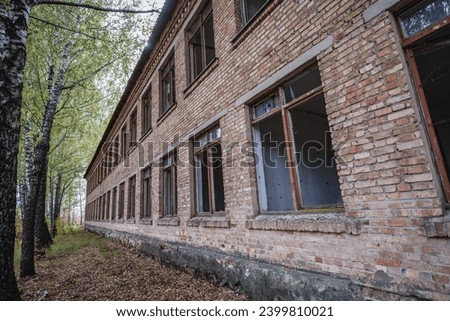 Exterior of school in Illinci abandoned village in Chernobyl Exclusion Zone, Ukraine Royalty-Free Stock Photo #2399810021