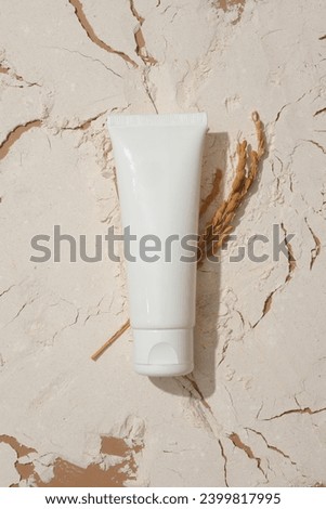 Close-up of a cosmetic tube on a background filled with rice bran powder. Rice bran powder contains many nutrients that are good for the skin. Concept of natural cosmetics. Royalty-Free Stock Photo #2399817995