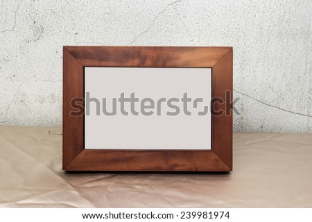 photo frame with space on fabric cover table and cement wall