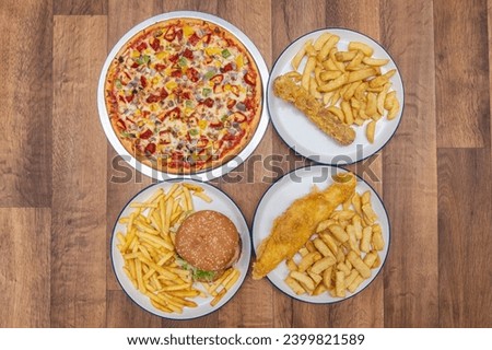 Chip Shop Food, deep fried food, battered food, fish and chips, black pudding, white pudding, burgers and chips, pies, chips, fish chips and peas Royalty-Free Stock Photo #2399821589