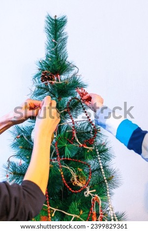 Close up shot of woman and little boy decorating christmas tree.