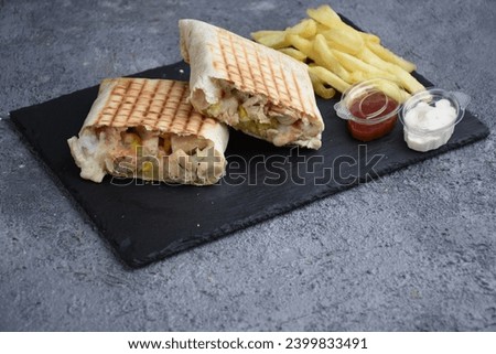 French tacos with fries, ketchup and mayonnaise , black stone plate