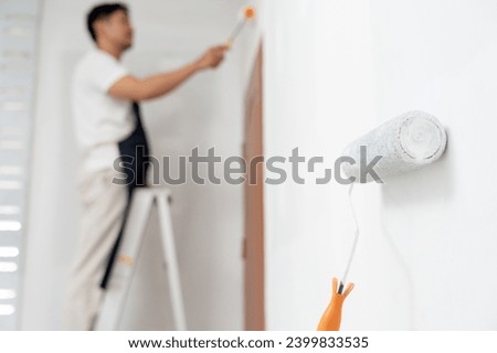 painter man, brush in hand for products to restore and paint the wall, indoor the building site of a house, wall during painting, renovation, painting, contractor, Architect, construction worker Royalty-Free Stock Photo #2399833535