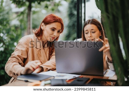 Young business professionals collaborate in a city cafe, discussing analytics, marketing strategies, and sales growth. Creative teamwork in an urban environment. Royalty-Free Stock Photo #2399845811