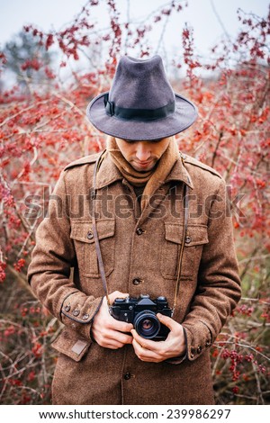 young man (tourist) looking through the camera and taking picture