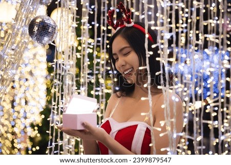 Woman opening magic Christmas Gift box. Beautiful New Year and Christmas scene. Miracles and wishes come true on Christmas eve.