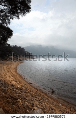 Exterior photo view of a water lake reservoir for the city of Hong Kong in Sai Kung with reservoir full of clean drinkable fresh water with the bank with soil and tree jungle forest all around