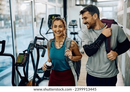 Happy couple of athletes coming to sports training in health club. Copy space.  Royalty-Free Stock Photo #2399913445