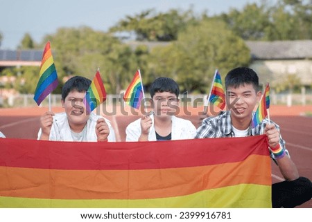 Asian boys hold rainbow flags, symbol of LGBT, in the running race to call all people to respect human gender diversity and celebrations LGBT event in Pride Month, June, around the world, new edited.
