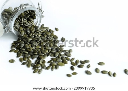 Natural green pumpkin seeds without shell isolated on white background. Healthy food concept. Overhead view. Copy space. Royalty-Free Stock Photo #2399919935