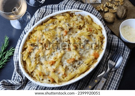 Homemade pasta with pumpkin, gorgonzola and walnuts in a white tray. Italian food concept. Overhead view. Royalty-Free Stock Photo #2399920051