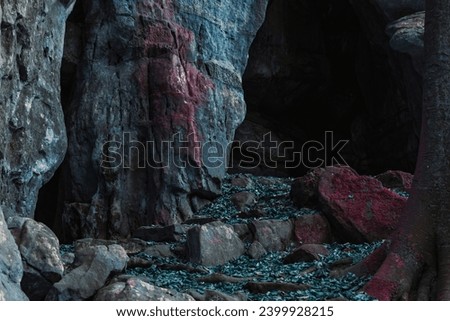 a cave with a blue rock. fantasy cave landscape. fantasy nature with dead blue leaves on the ground. rocky path in fantasy colors. alien environment of rock cave entrance