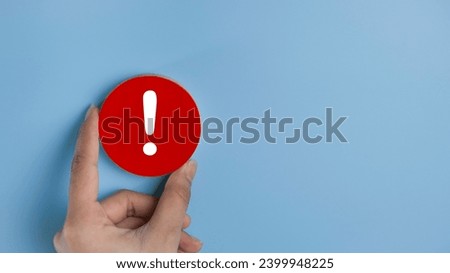 Attention caution warning concept. Hand holding red page with exclamation error mark for important alert signal, Hazard, risk ,danger background with copyspace.