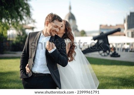 Happy bride and groom embracing and having fun after wedding ceremony. Loving couple at the street. Stock photo 