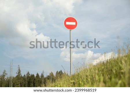 Stop sign on mountain. Road sign on hill. Round plate. Green Holi.