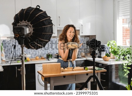 mature woman cooking at home recording video tutorial blogger - social media -