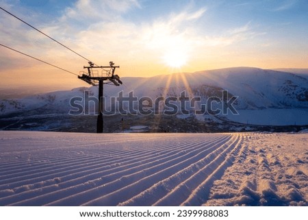 Winter evening panorama of Kirovsk. Ski slopes at Bigwood ski resort. Sunset in polar city. (Kirovsk, Russia, Murmansk Oblast, Kola Peninsula, known as Khibinogorsk, cold winter weather)