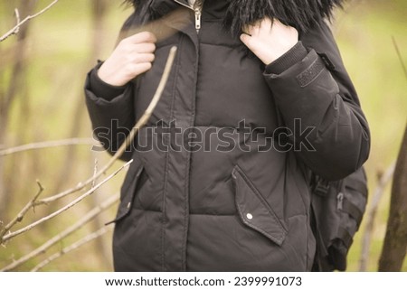 Young woman taking a stroll in the forest as a weekend activity in autumn
