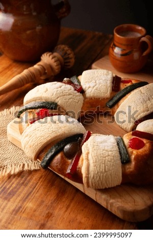 Three Kings Bread also called Rosca de Reyes, Roscon, Epiphany Cake, traditionally served with hot chocolate in a clay Jarrito. Mexican tradition on January 5th. Royalty-Free Stock Photo #2399995097
