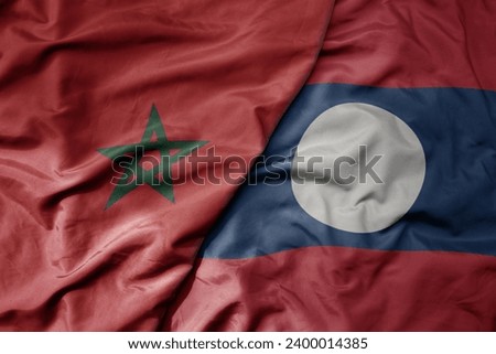 big waving national colorful flag of laos and national flag of morocco . macro