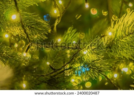 background of a decorated Christmas tree with heart-shaped ornaments. Christmas tree decoration with yellow gold lights background