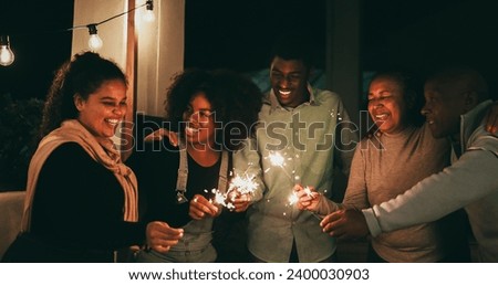 African family having fun hugging each other and celebrate during new year's eve with firework sparkler - Holidays and vacation concept - Soft focus on mother face Royalty-Free Stock Photo #2400030903