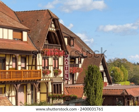 Hotel signage prominently featured on the facade of a traditional timbered Alsatian house, embodying the region's architectural charm