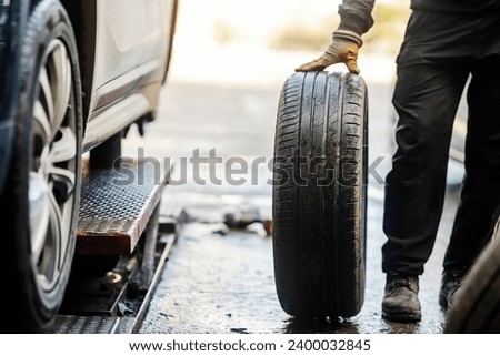 Cropped picture of an unrecognizable auto mechanic with car tire.