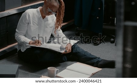 Female inspector reading information on case files, trying to solve crime with clues and surveillance photos. Police officer examining forensic evidence checking suspect background.