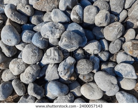 portrait of piles of river stones as building materials for houses