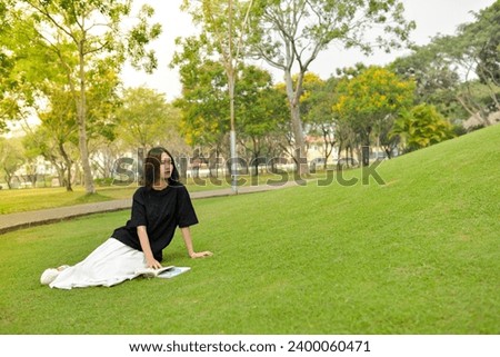 High-quality, free stock photo college students in campus environment, studying, enjoying simple moments, authenticity, a day in the life. She is studying on the green grass