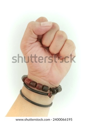 hands clenched upwards wearing bracelets on a white background