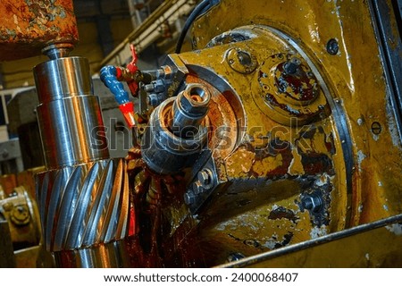 Processing helical gear with old modular hob machine tool Royalty-Free Stock Photo #2400068407