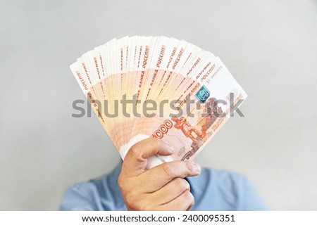 million rubles in hand. Close-up men's hands hold a wad of Russian money five thousand bills. Royalty-Free Stock Photo #2400095351