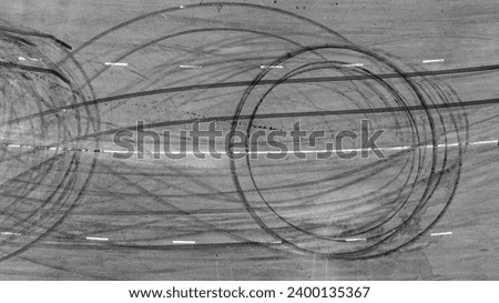 Aerial top view car tire marks burnout, Tire marks on the asphalt road, Tire mark on race track texture and background. Royalty-Free Stock Photo #2400135367