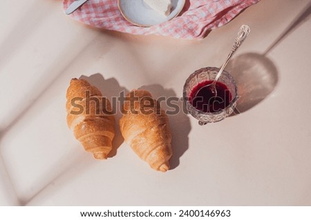 Two delicious freshly baked croissants on beige background top view breakfast bright light sunny shot relationship concept
