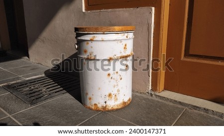 Rusty bucket in front of home Royalty-Free Stock Photo #2400147371