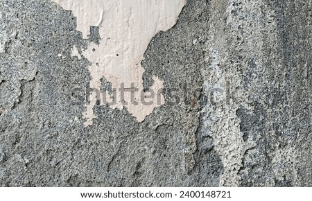 Abstract Rough Dry paint is peeling off the building wall.Close-up. Badly fixed building facade wall covered with cracks in stucco and paint. Missing patch of paint in the middle; crack with flappy. Royalty-Free Stock Photo #2400148721
