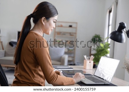 Young Asia businesswoman use laptop with blank white screen mock up display for advertising text while working at her workplace