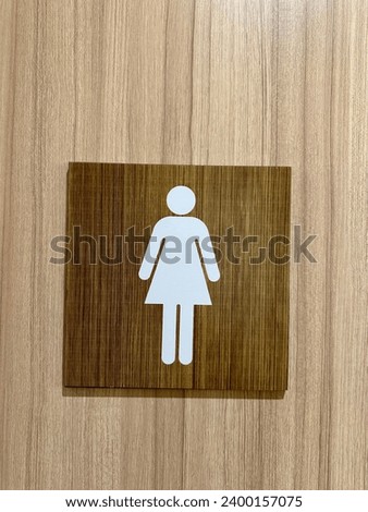 Ladies toilets symbol signs. Material light wood.