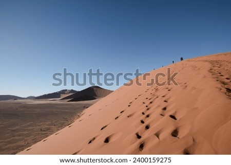 A red sand dune with textures and patterns, people far away, Namibian dune 7