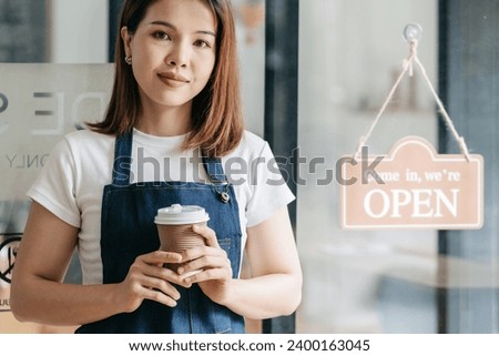 Owner of the cafe stands at the door with a sign Open waiting for customers. Small business concept, cafes and restaurants.